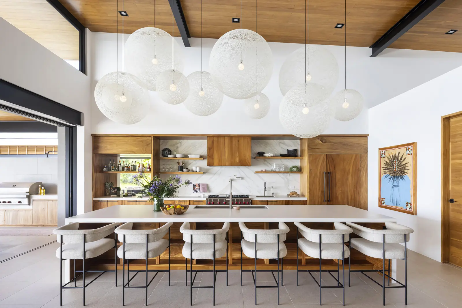 Kitchen with a long island and clustered globe pendants