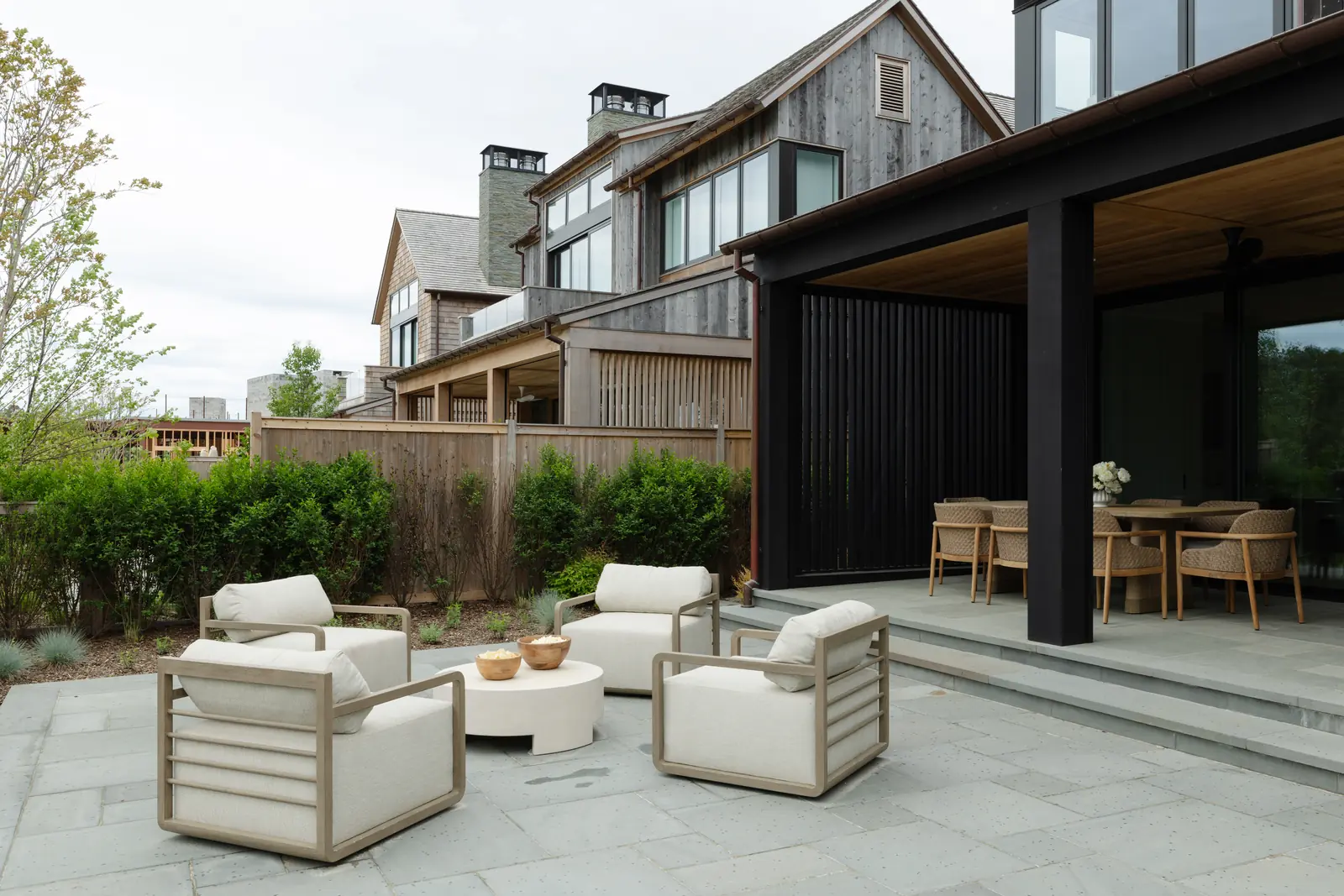 The Hamptons residence from the garden, covered terrace and lounge chairs