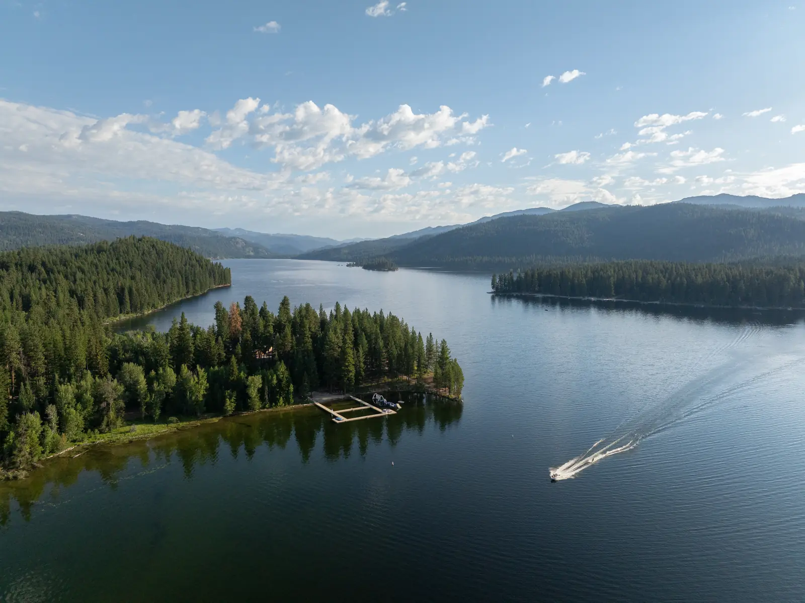 Aerial view of a forested point on a mountain lake